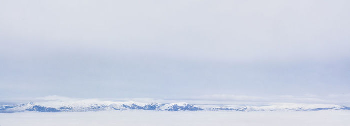 Snow covered landscape against sky