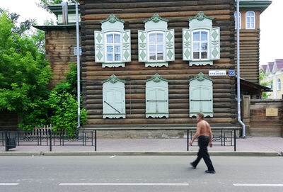 Full length of man walking on street against building