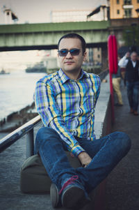 Portrait of young man sitting in sunglasses