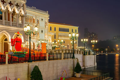 Statue of illuminated buildings in city at night