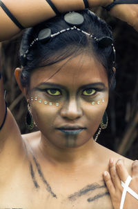 Close-up portrait of shirtless female model with tribal make-up