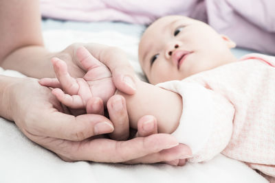 Close-up of baby lying on bed