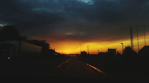 View of road against cloudy sky at sunset