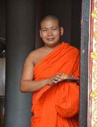 Portrait of smiling man standing against wall