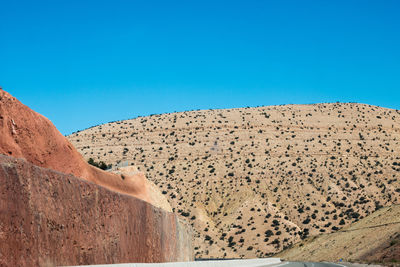 Scenic view of arid landscape against clear blue sky