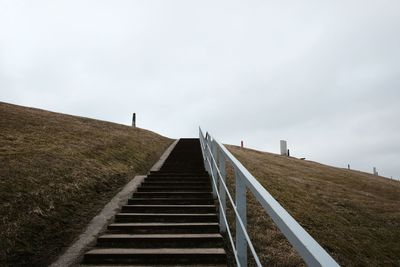 Low angle view of staircase on hill against sky