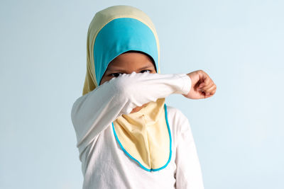 Portrait of person standing against white background