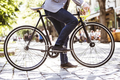 Unrecognizable businessman with bicycle in the city