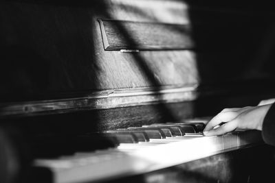 Cropped hands of man playing piano