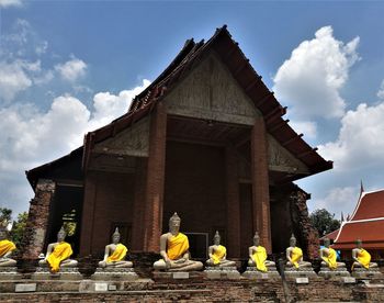 Statue by building against sky