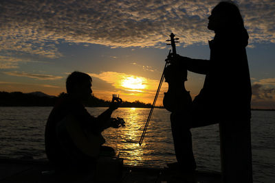 Silhouette people on beach during sunset