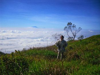 Man standing on field against sky