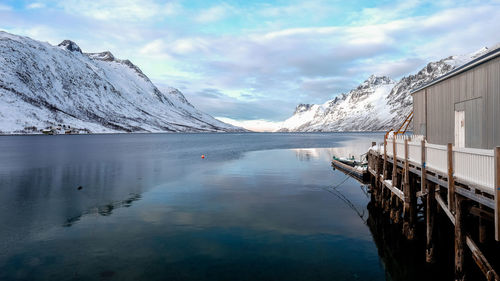 Scenic view of lake by snowcapped mountains against sky