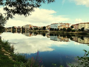 Scenic view of lake by buildings against sky