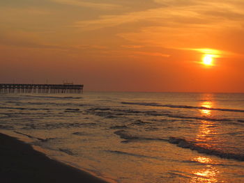 Scenic view of sea against orange sky