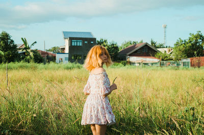 Woman standing on field against sky