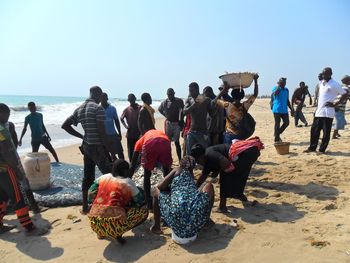 People at beach against clear sky