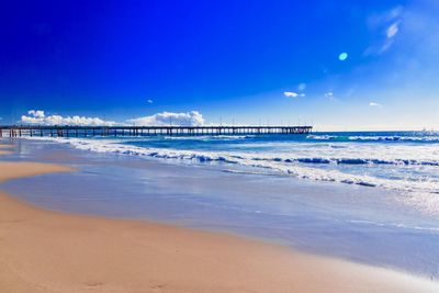 Scenic view of beach against blue sky