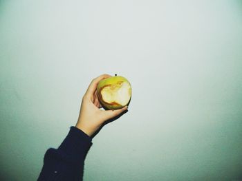 Cropped image of hand holding food over white background