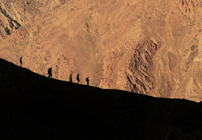 Silhouette people hiking on mountain