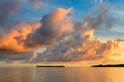 Scenic view of sea against dramatic sky during sunset