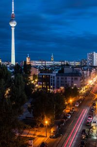 High angle view of light trails on road amidst buildings in city