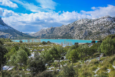 Scenic view of lake by mountains against sky