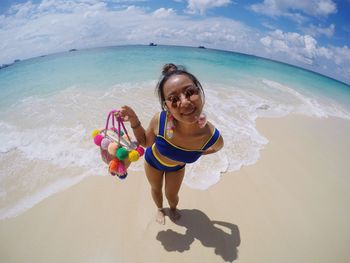 Portrait of smiling young woman standing on beach