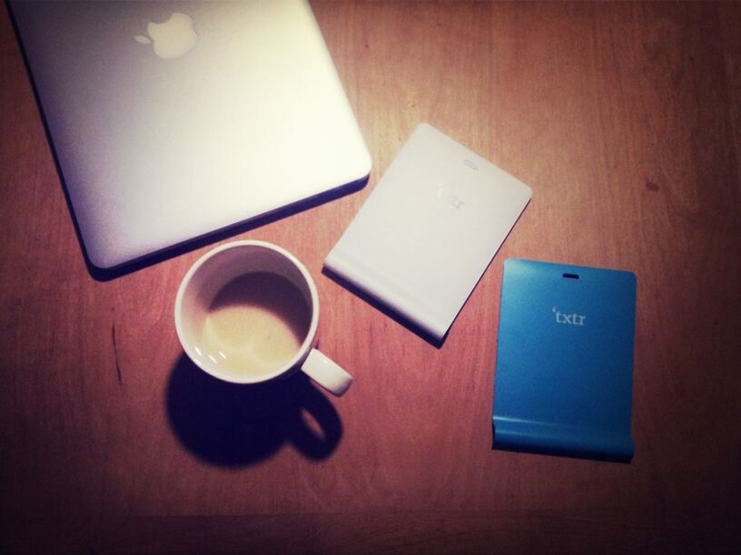 indoors, table, communication, still life, close-up, technology, coffee cup, wireless technology, high angle view, text, laptop, no people, connection, western script, home interior, drink, computer keyboard, paper, food and drink, refreshment