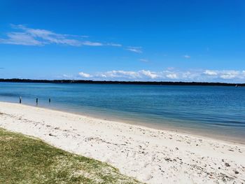 Scenic view of beach against blue sky