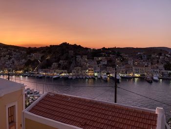 Sunset above symi island,greece. vanilla sky. town lights, yachts moored in marina.dream destination