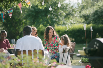 Happy multi-generation family having lunch together at patio during garden party