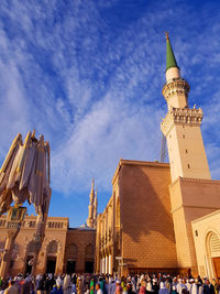 Group of people in front of cathedral against sky