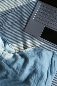 High angle view of laptop on bed