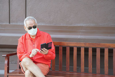 Man using mobile phone while standing on railing