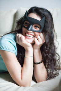 Cheerful young woman wearing batman mask