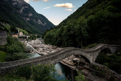 Arch bridge over river against sky