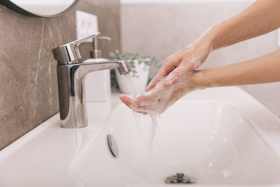 Washing hands under the flowing water tap. washing hands rubbing with soap for corona virus