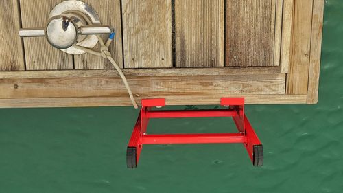 High angle view of bollard and red ladder on pier over sea