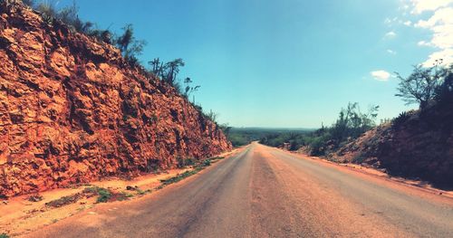 Road amidst trees against clear sky