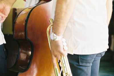 Midsection of man holding trumpet