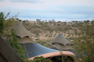 Tent on field by trees against sky