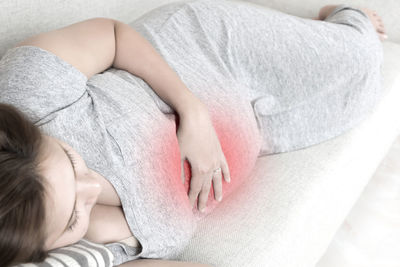 Pregnant young woman sleeping on sofa at home