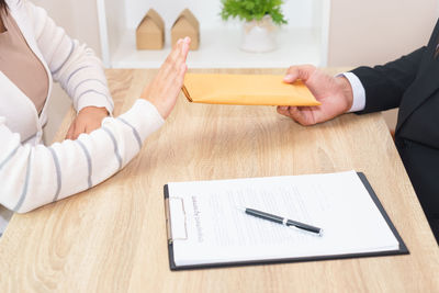 Close-up of a hand holding pen on table