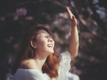 Portrait of smiling young woman looking away outdoors