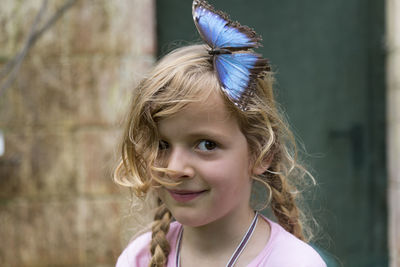 Portrait of smiling girl with butterfly on her head