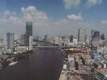 Aerial view of city against cloudy sky