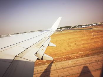 Airplane wing against clear sky