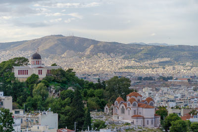 Buildings in town against cloudy sky