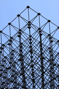 Low angle view of silhouette electricity pylon against sky